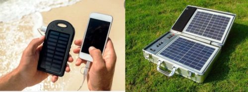 Hand held solar power bank charging phone and portable solar panel on green grass in sunlight.